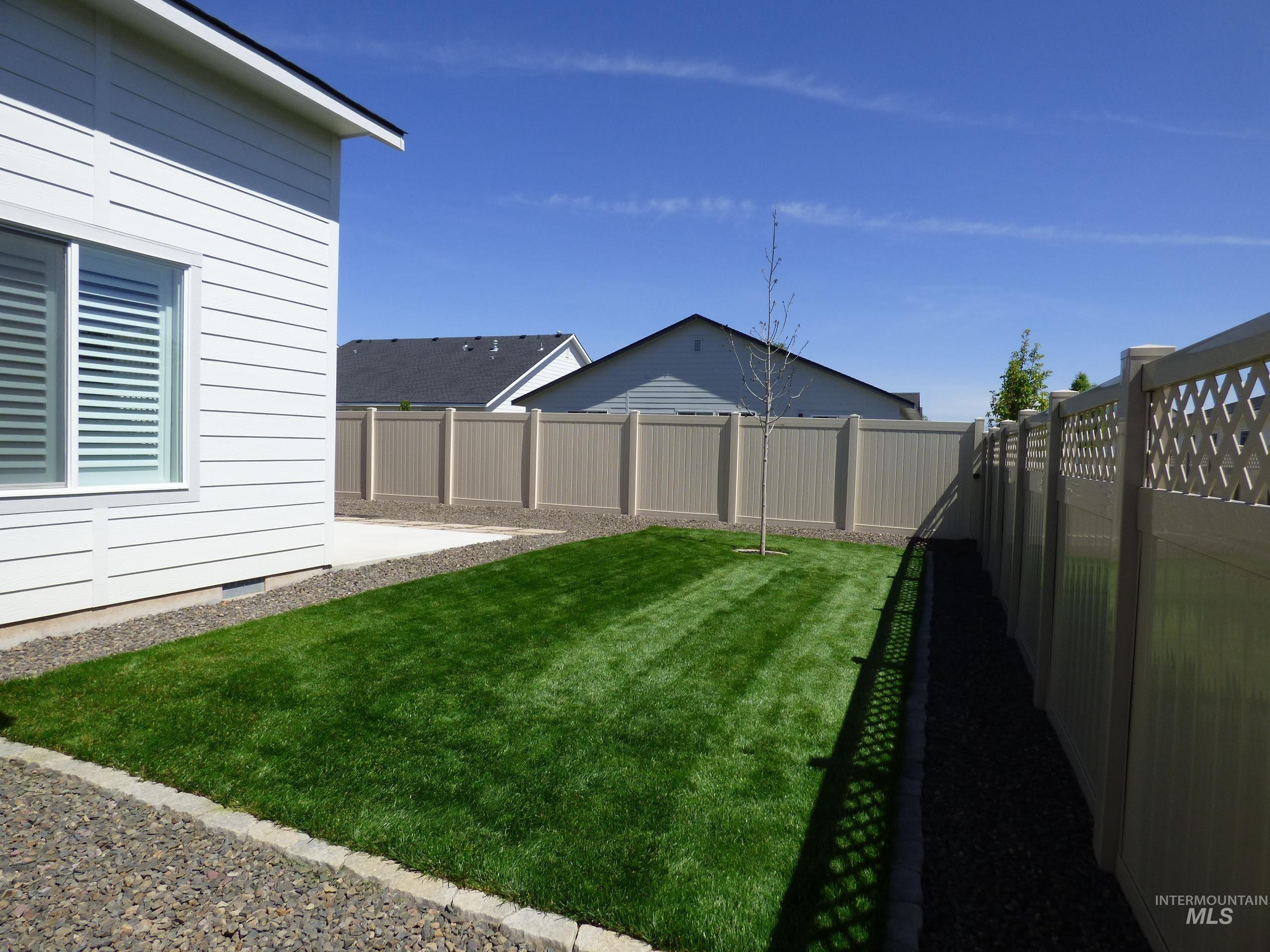 2708 East Buckaroo Drive Kuna, ID 83634 - Photo 41 of 48 Expansive rear yard featuring a manicured lawn, a young deciduous tree, and perimeter fencing