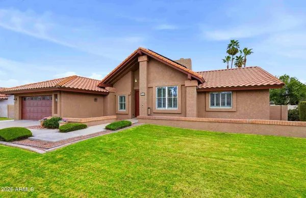 a yellow and red house sitting in middle of the grass