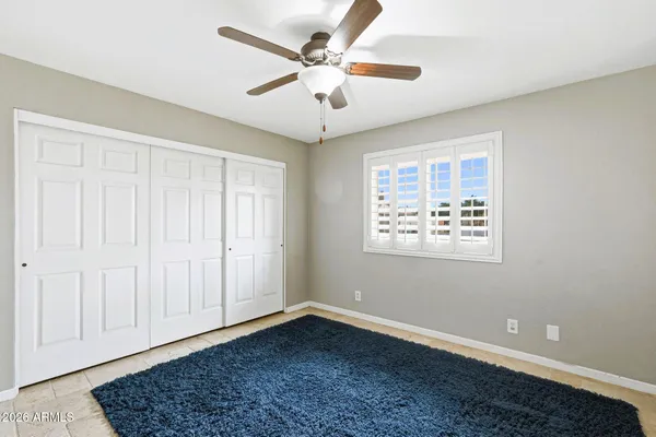 a view of an empty room with a window and a ceiling fan