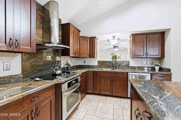 a kitchen with stainless steel appliances granite countertop a sink stove and cabinets
