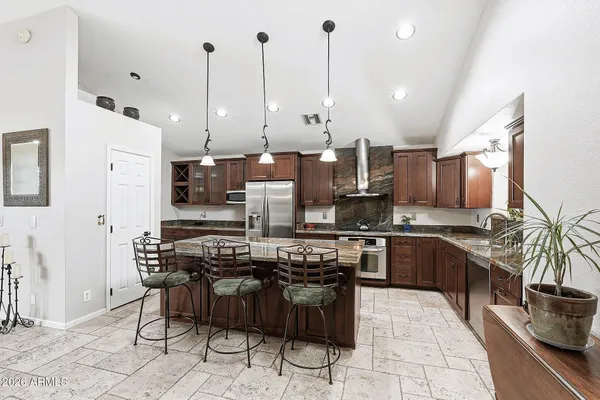 a kitchen with stainless steel appliances kitchen island granite countertop a stove a sink a counter space and cabinets