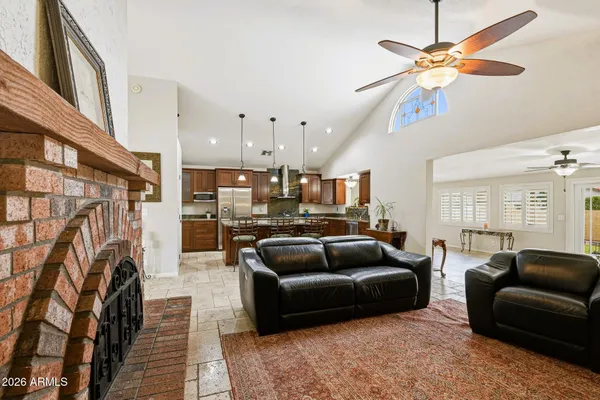 a living room with furniture a fireplace and a chandelier