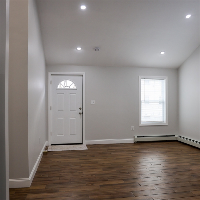 598 School Street, Unit REAR ADU Lowell, MA 01851 - Photo 14 of 42 an empty room with wooden floor and windows
