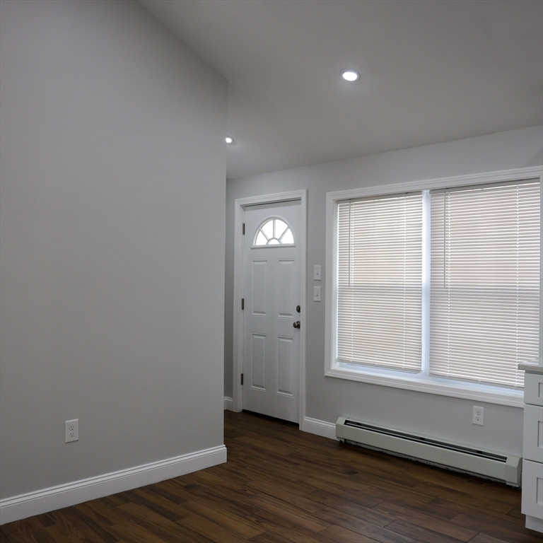 598 School Street, Unit REAR ADU Lowell, MA 01851 - Photo 15 of 42 a view of an empty room with wooden floor and a window