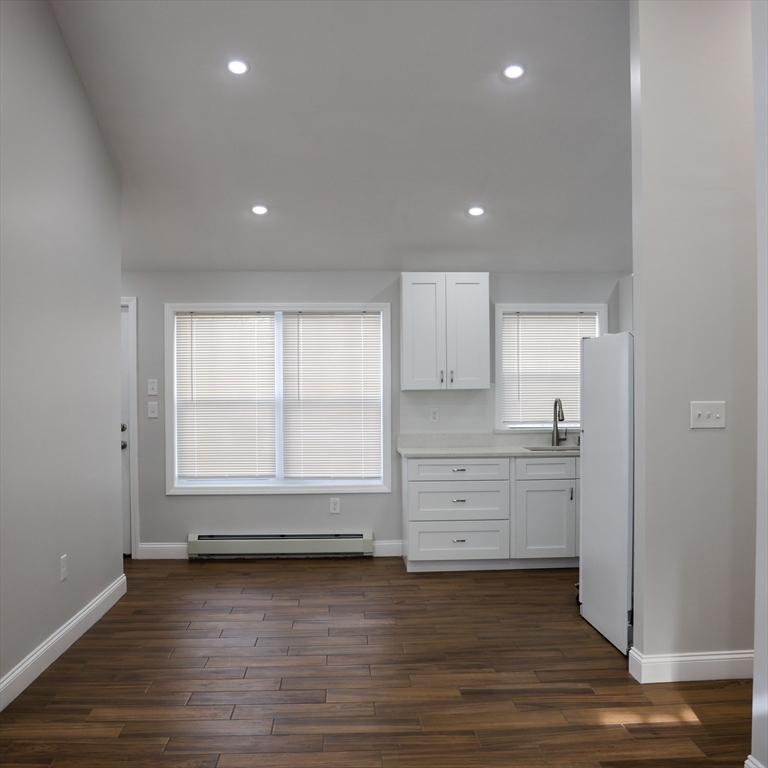 598 School Street, Unit REAR ADU Lowell, MA 01851 - Photo 20 of 42 a view of a kitchen with wooden floor and a sink