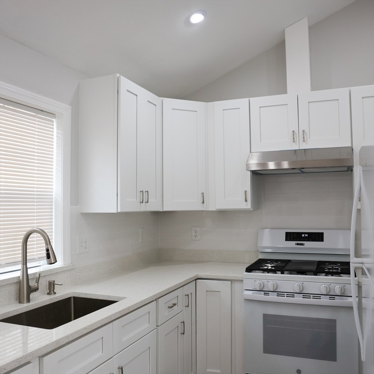 598 School Street, Unit REAR ADU Lowell, MA 01851 - Photo 22 of 42 a kitchen with white cabinets and white appliances