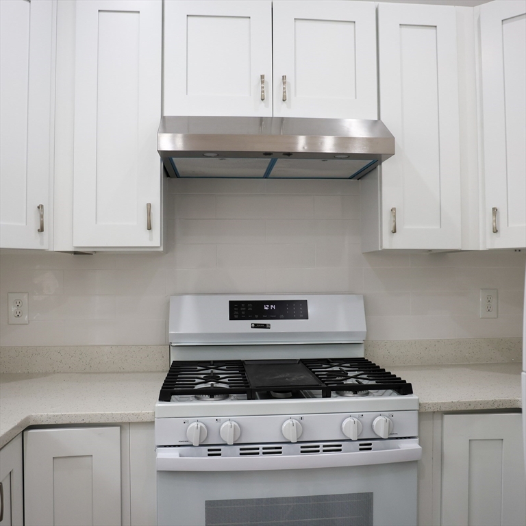 598 School Street, Unit REAR ADU Lowell, MA 01851 - Photo 24 of 42 a stove top oven sitting inside of a kitchen