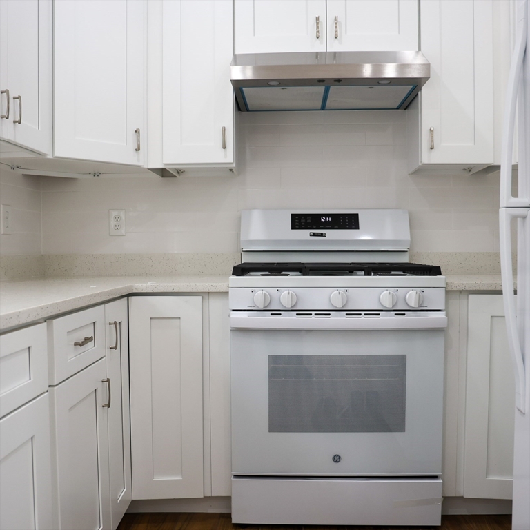 598 School Street, Unit REAR ADU Lowell, MA 01851 - Photo 25 of 42 a stove top oven sitting inside of a kitchen