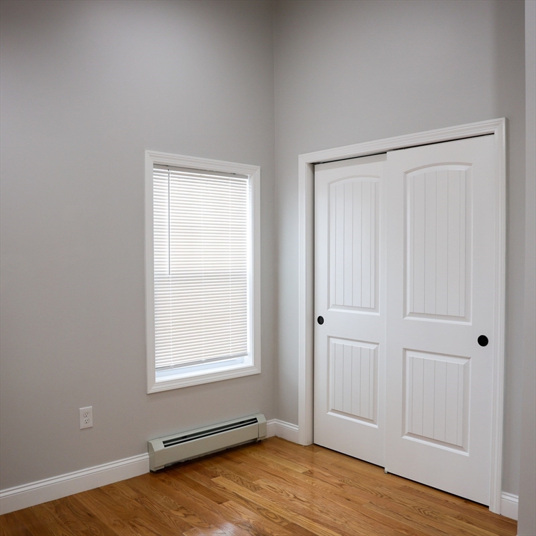 598 School Street, Unit REAR ADU Lowell, MA 01851 - Photo 32 of 42 an empty room with wooden floor and windows
