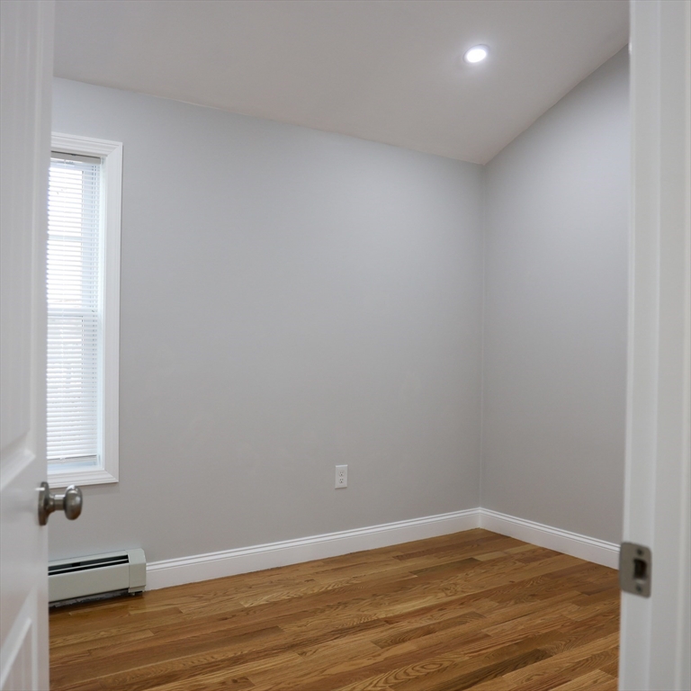 598 School Street, Unit REAR ADU Lowell, MA 01851 - Photo 34 of 42 an empty room with wooden floor and window