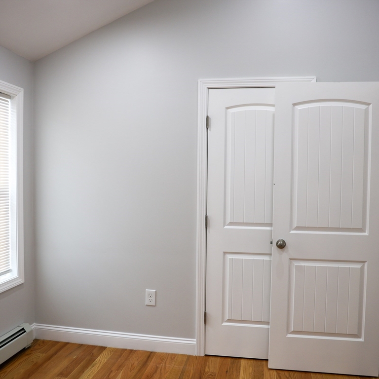 598 School Street, Unit REAR ADU Lowell, MA 01851 - Photo 38 of 42 an empty room with wooden floor and closet