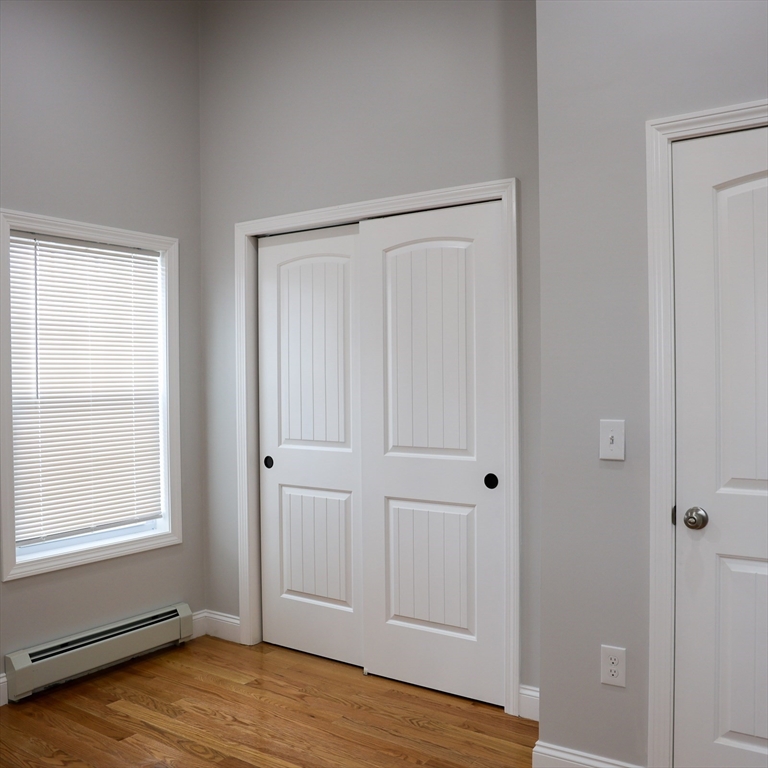 598 School Street, Unit REAR ADU Lowell, MA 01851 - Photo 39 of 42 a view of empty room with wooden floor and entryway