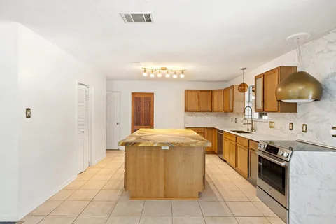 a kitchen with stainless steel appliances granite countertop a sink stove and cabinets