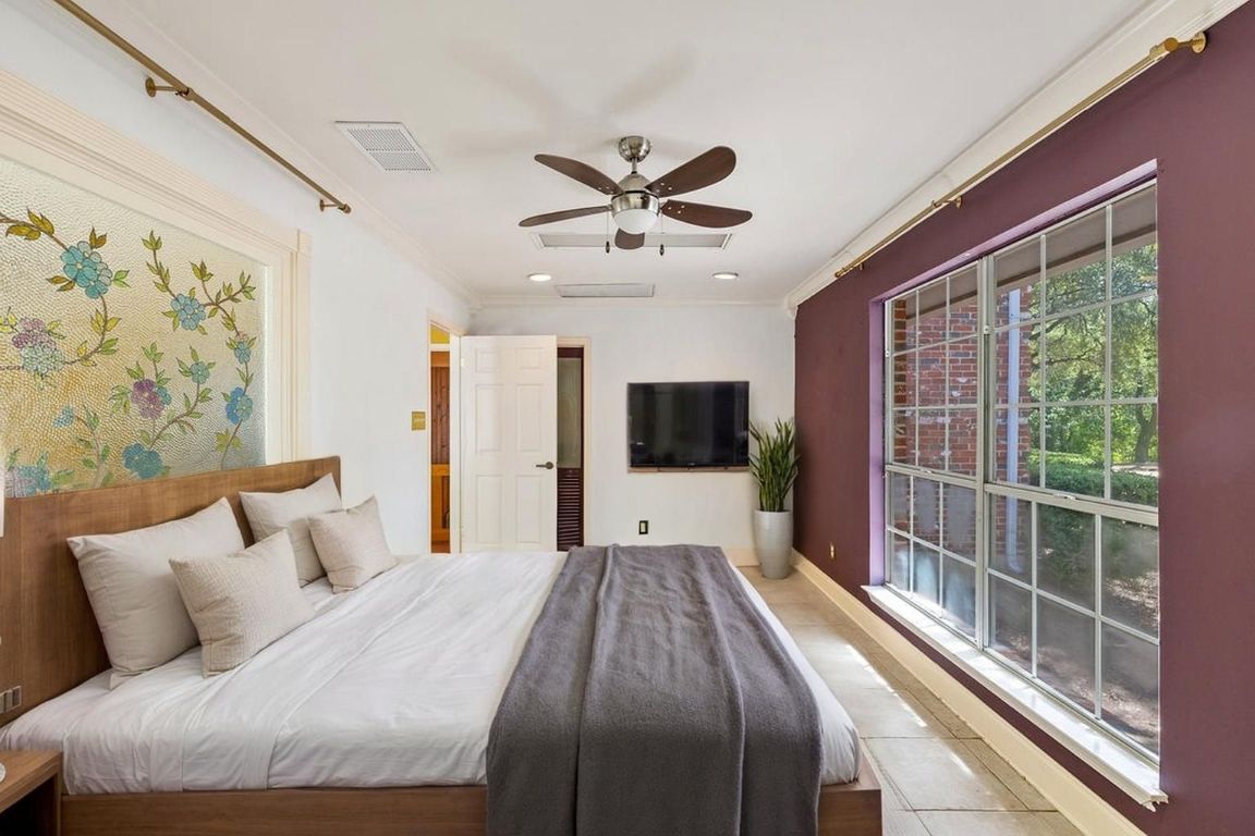 2412 Jones Road Austin, TX 78745 - Photo 15 of 40 a bedroom with a large bed and a flat screen tv