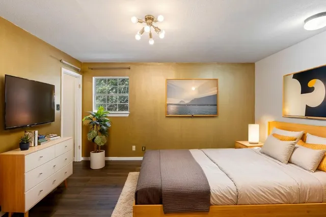 a bedroom with a bed and a flat screen tv