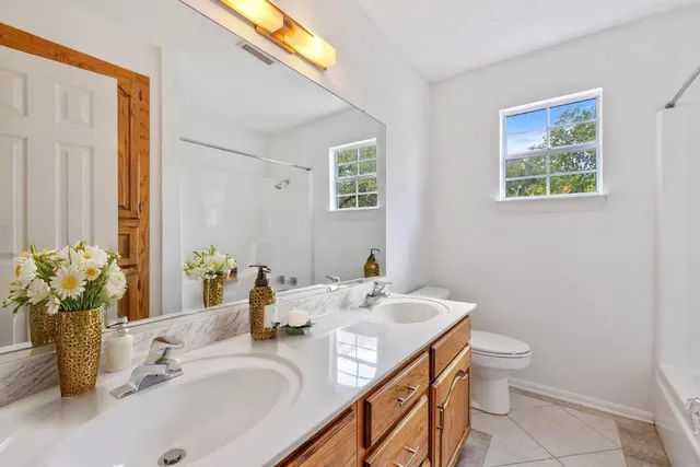 a bathroom with a granite countertop sink toilet and a mirror