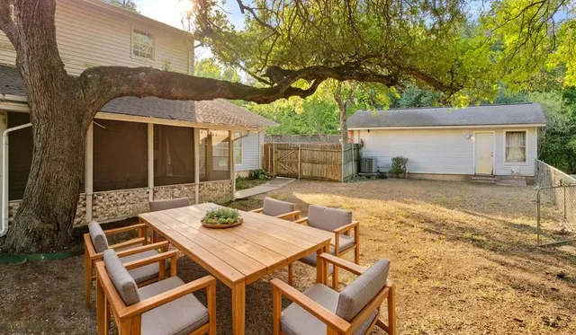 a view of a patio with table and chairs with wooden fence and floor