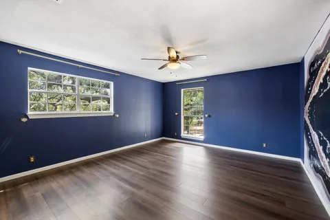 a view of an empty room with a window and a ceiling fan