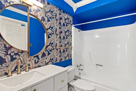 a bathroom with a sink and mirror with toilet
