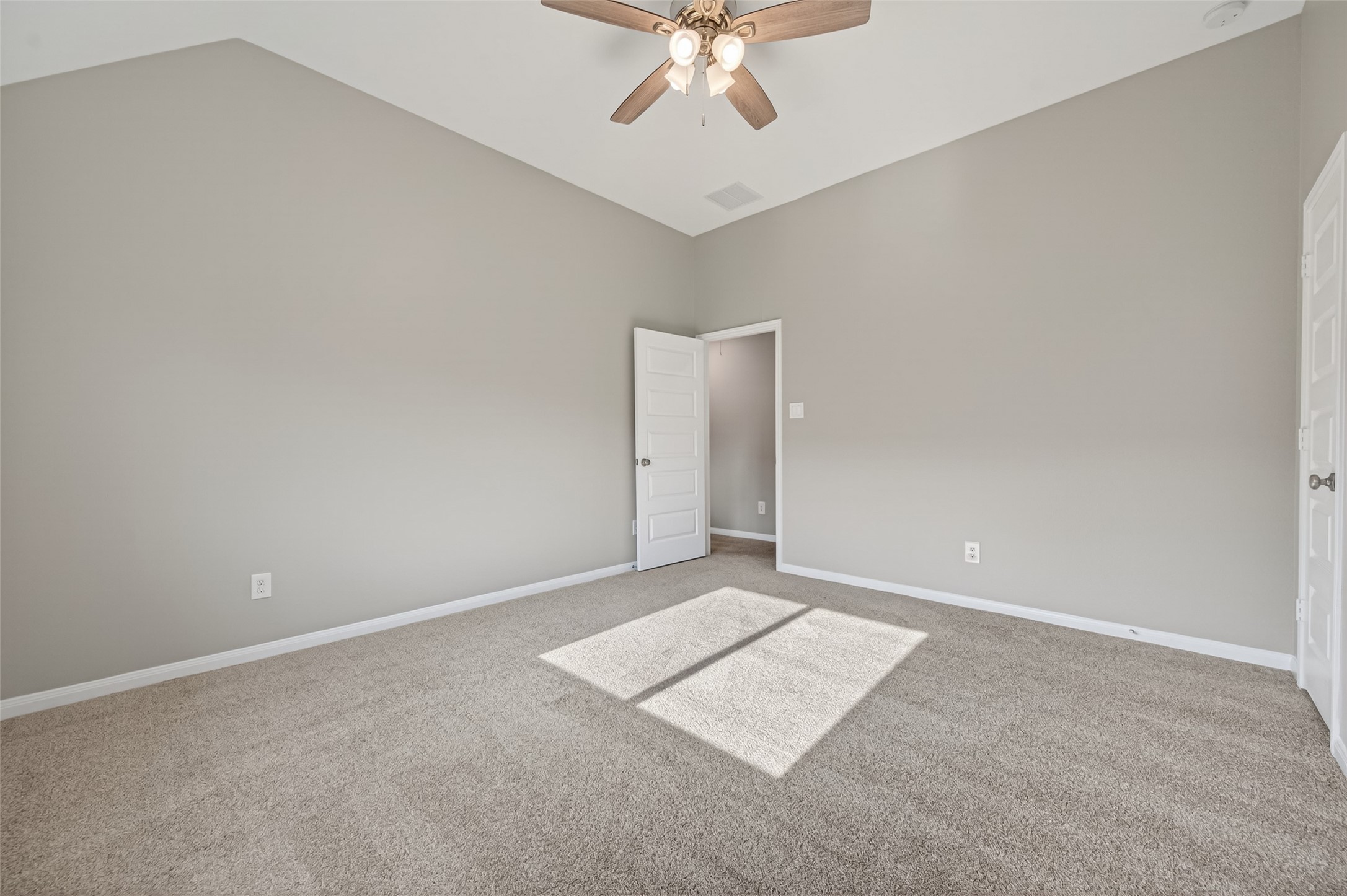 7003 Bristol Memorial Drive Spring, TX 77379 - Photo 39 of 40 Spacious secondary bedroom in this Spring TX 77379 home featuring vaulted ceilings, plush carpeting, and abundant natural light. The generous layout provides flexibility for a variety of furniture configurations, while the walk-in closet adds valuable storage. Direct access to the Jack-and-Jill bathroom enhances functionality and convenience. Located on the upper level, this well-sized bedroom complements the smart, multi-bedroom floorplan in this move-in ready home