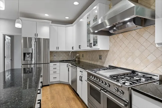 a kitchen with stainless steel appliances granite countertop a stove and a refrigerator