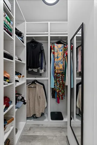 a view of walk in closet with clothes and shoes
