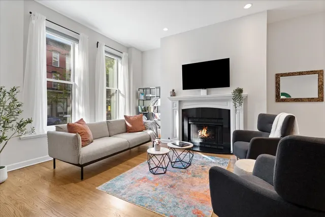 a living room with furniture a flat screen tv and a fireplace