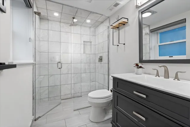 a bathroom with a sink toilet a mirror and shower