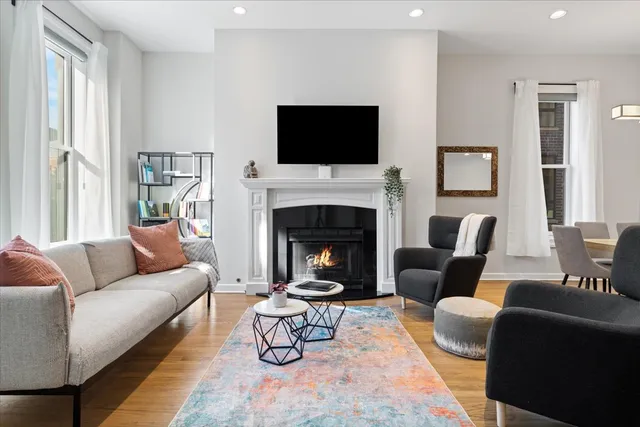 a living room with furniture a flat screen tv and a fireplace