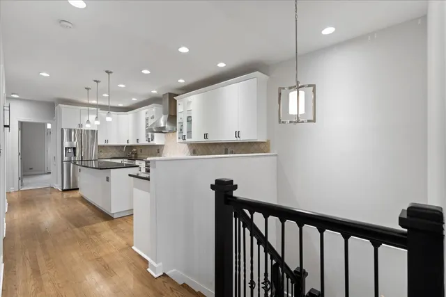 a kitchen with kitchen island white cabinets and stainless steel appliances
