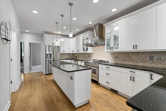 a kitchen with stainless steel appliances granite countertop a sink a stove and a refrigerator