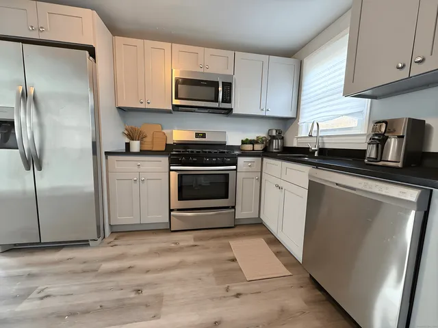 a kitchen with cabinets stainless steel appliances and a counter space