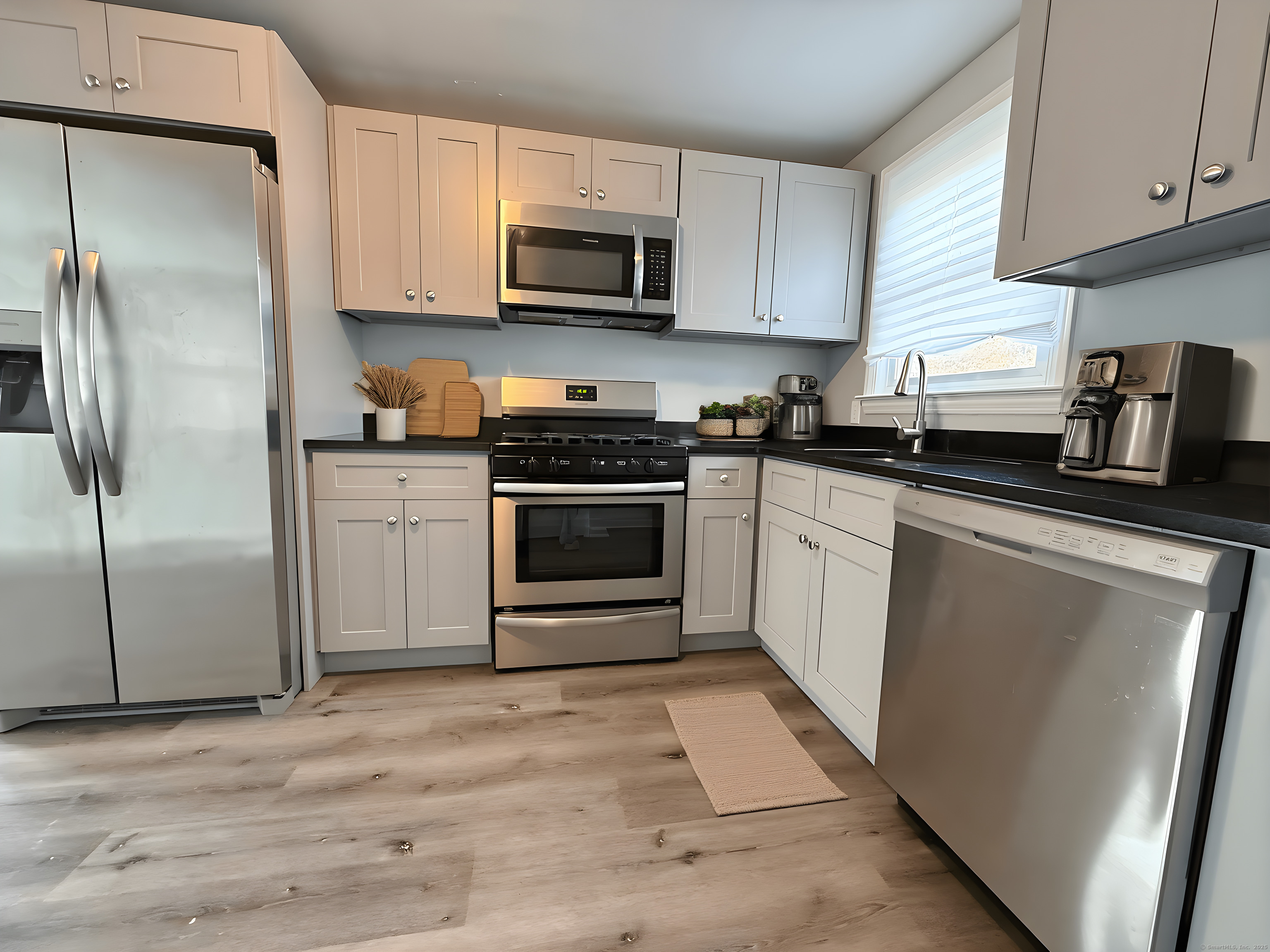 a kitchen with cabinets stainless steel appliances and a counter space