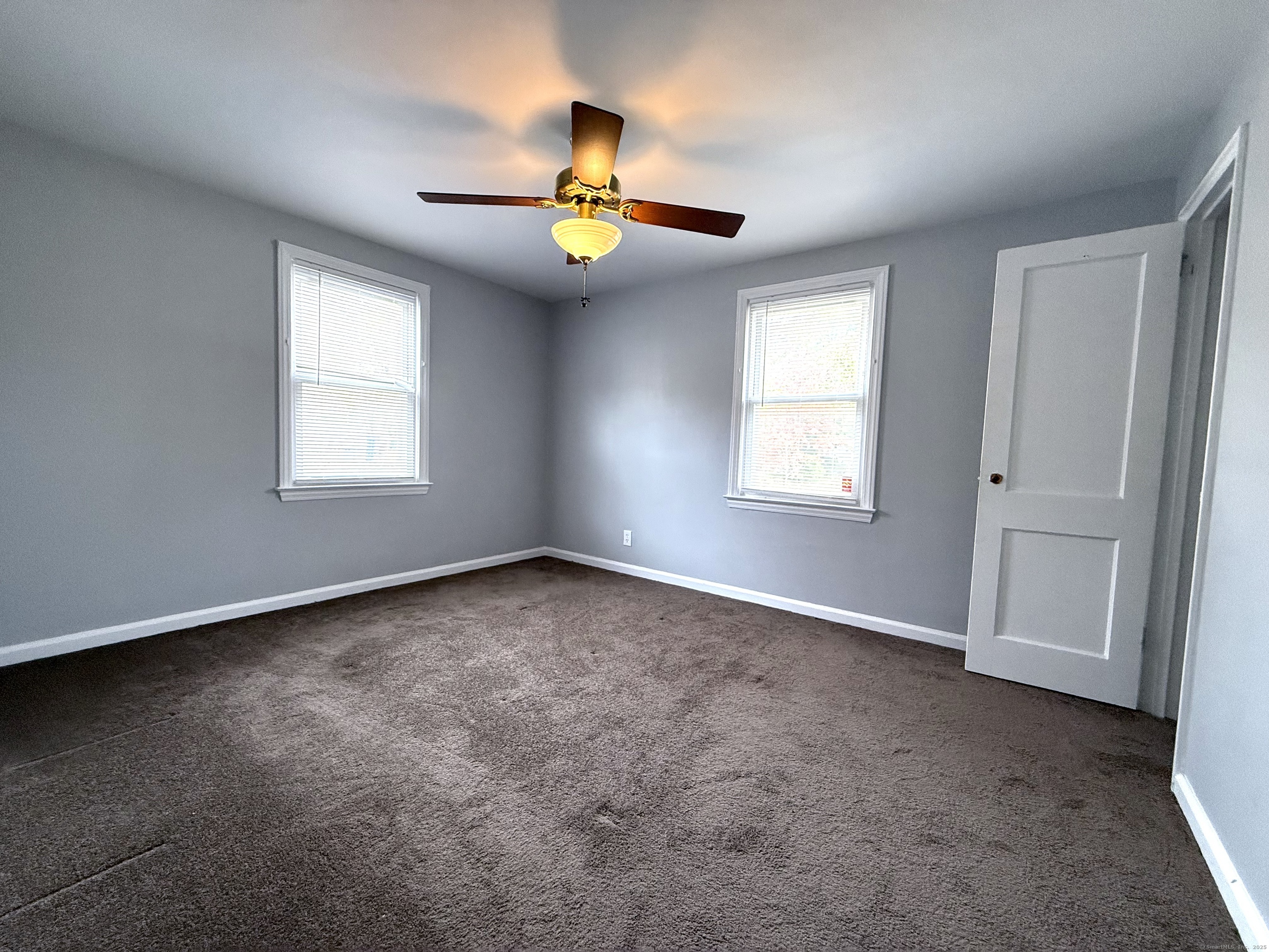 211 Spencer Street Naugatuck, CT 06770 - Photo 11 of 25 an empty room with windows and chandelier fan