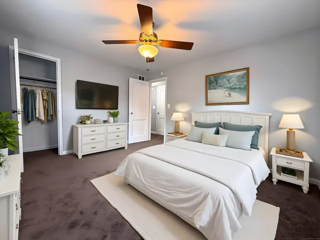 a spacious bedroom with a bed and a flat screen tv