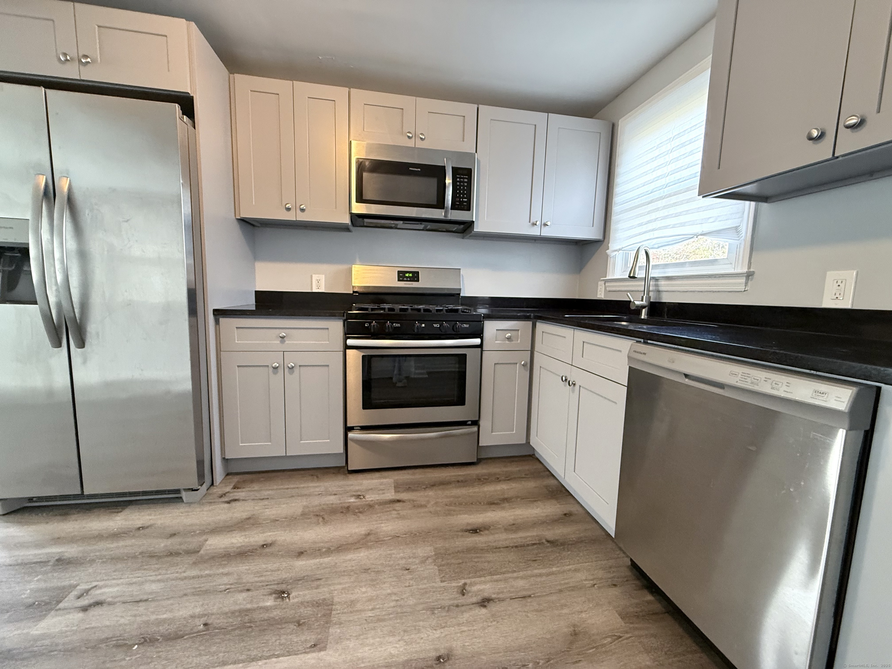 211 Spencer Street Naugatuck, CT 06770 - Photo 6 of 25 a kitchen with stainless steel appliances granite countertop a stove a refrigerator and a microwave