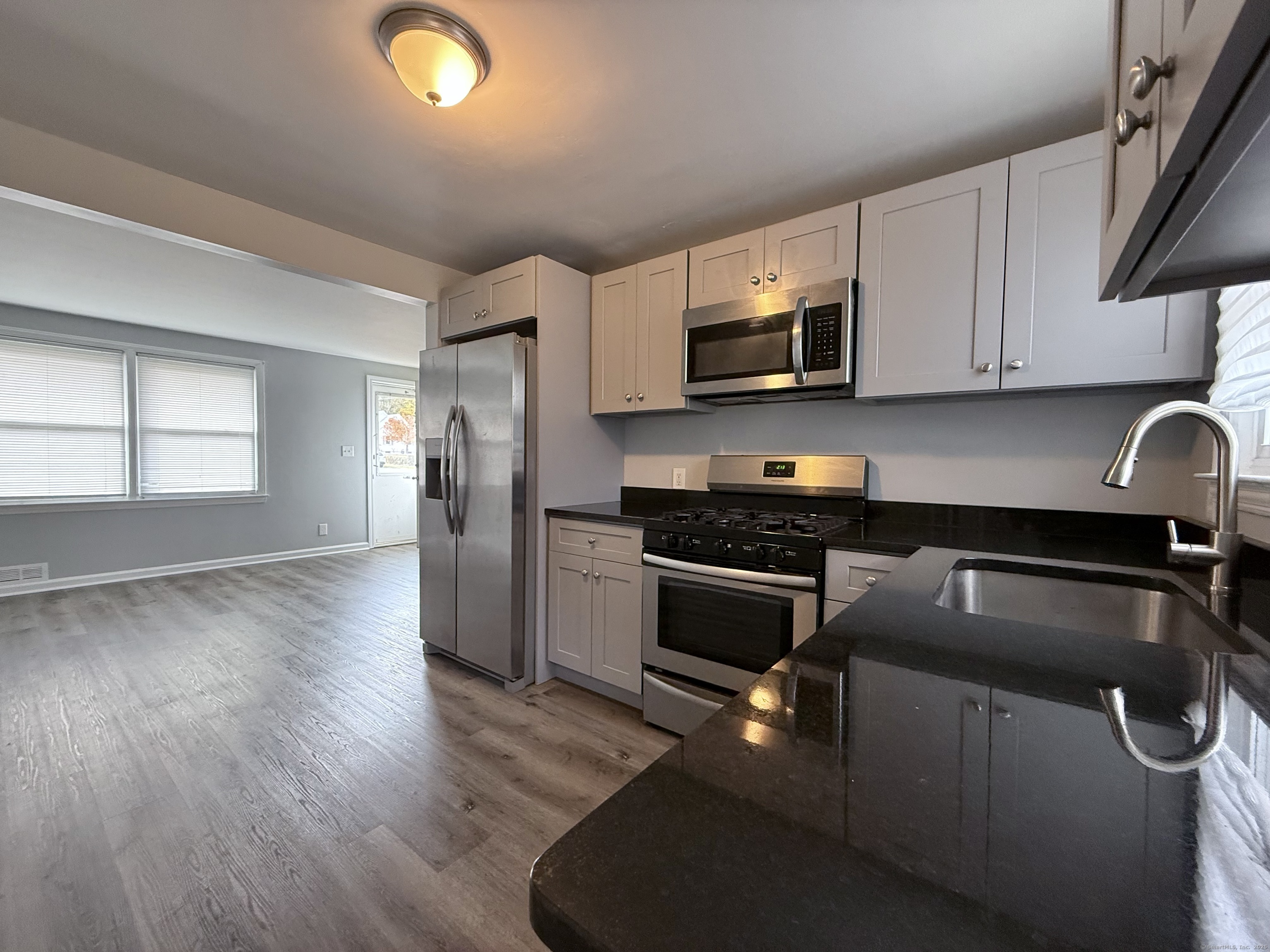211 Spencer Street Naugatuck, CT 06770 - Photo 7 of 25 a kitchen with granite countertop a refrigerator stove and microwave