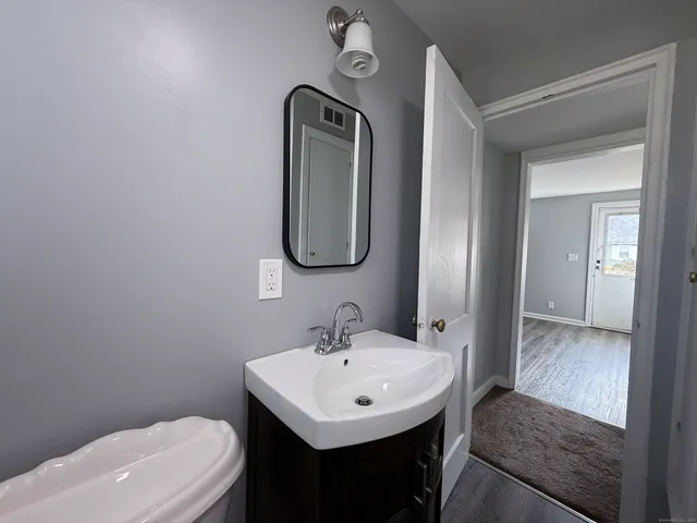 a bathroom with a toilet sink and mirror