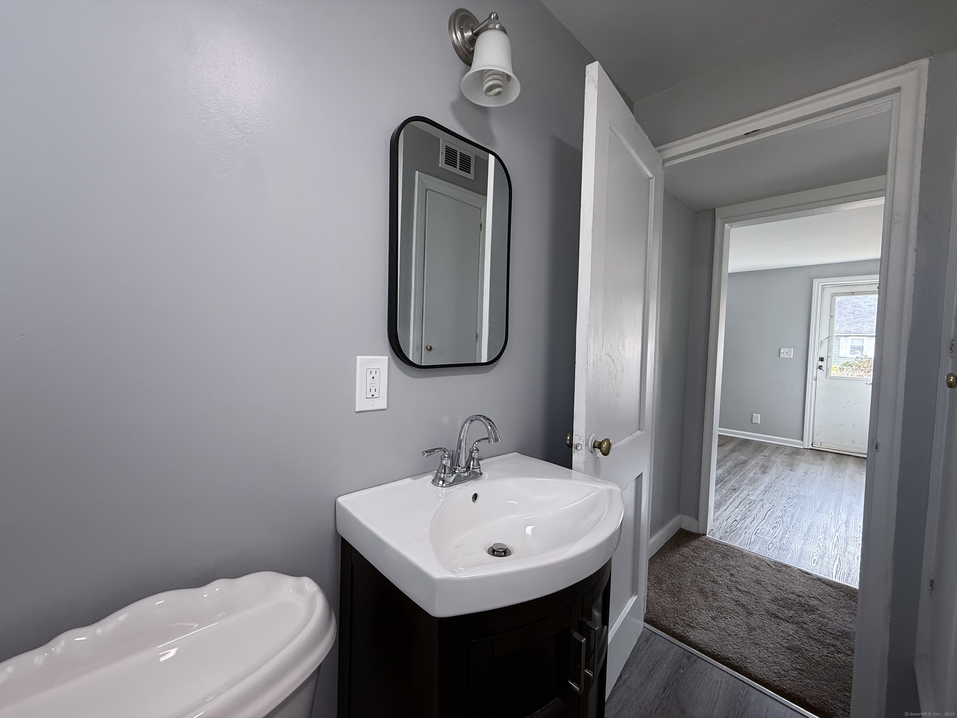 211 Spencer Street Naugatuck, CT 06770 - Photo 9 of 25 a bathroom with a toilet sink and mirror