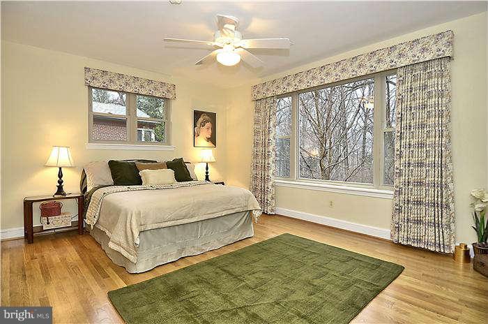 9314 Harvey Road Silver Spring, MD 20910 - Photo 7 of 7 a spacious bedroom with a large bed and a chandelier