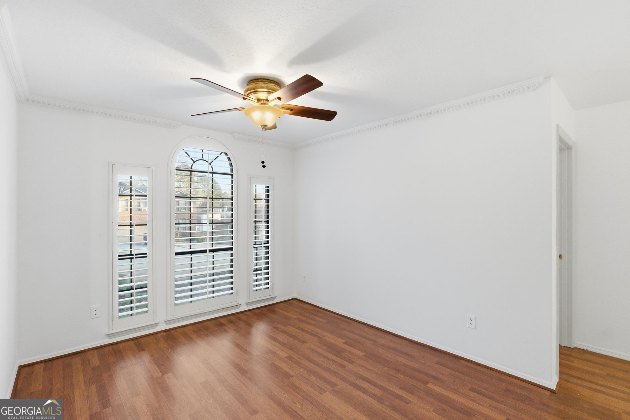 523 North Shore Road Lithonia, GA 30058 - Photo 11 of 26 an empty room with wooden floor chandelier fan and windows
