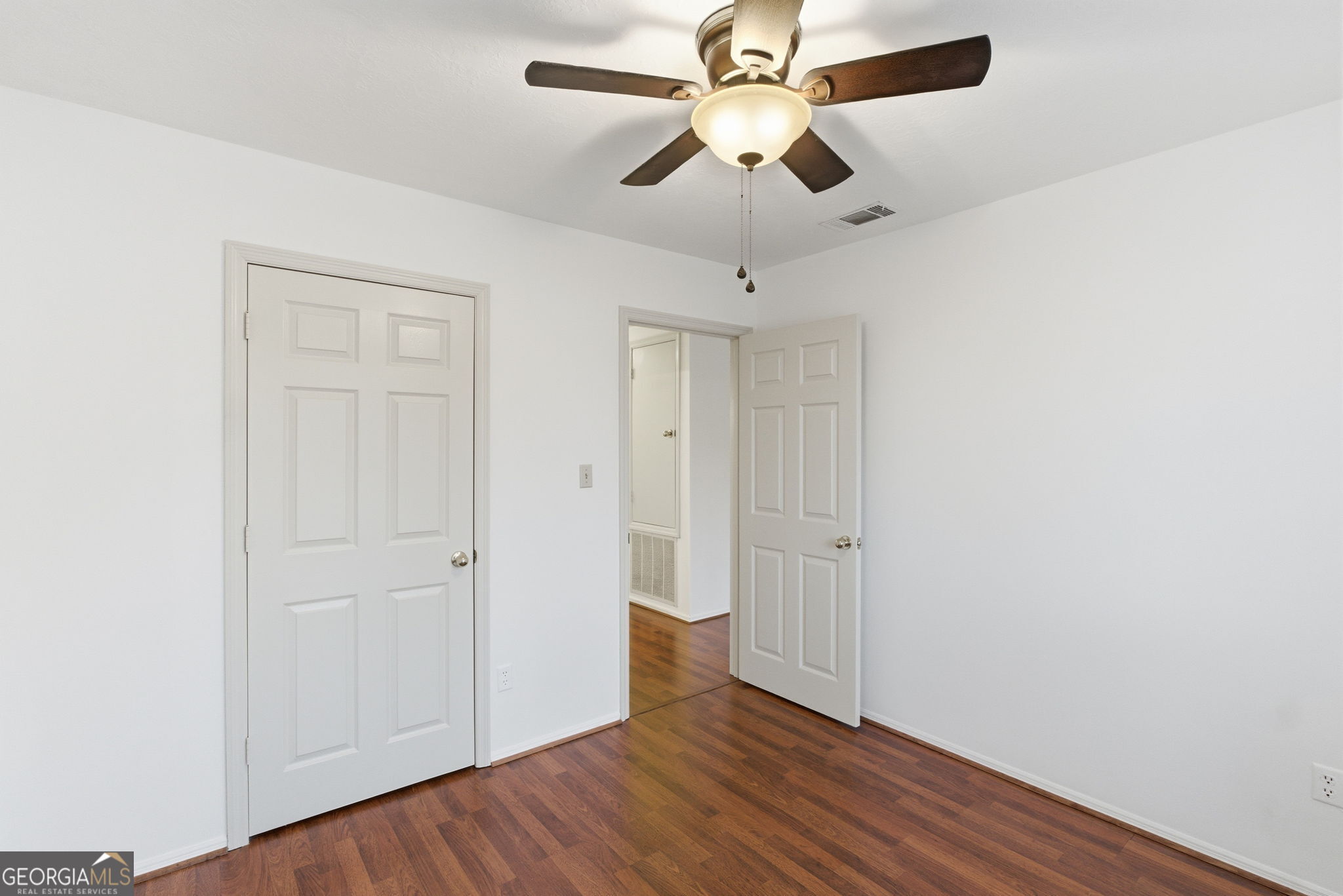 523 North Shore Road Lithonia, GA 30058 - Photo 20 of 26 an empty room with wooden floor fan and windows