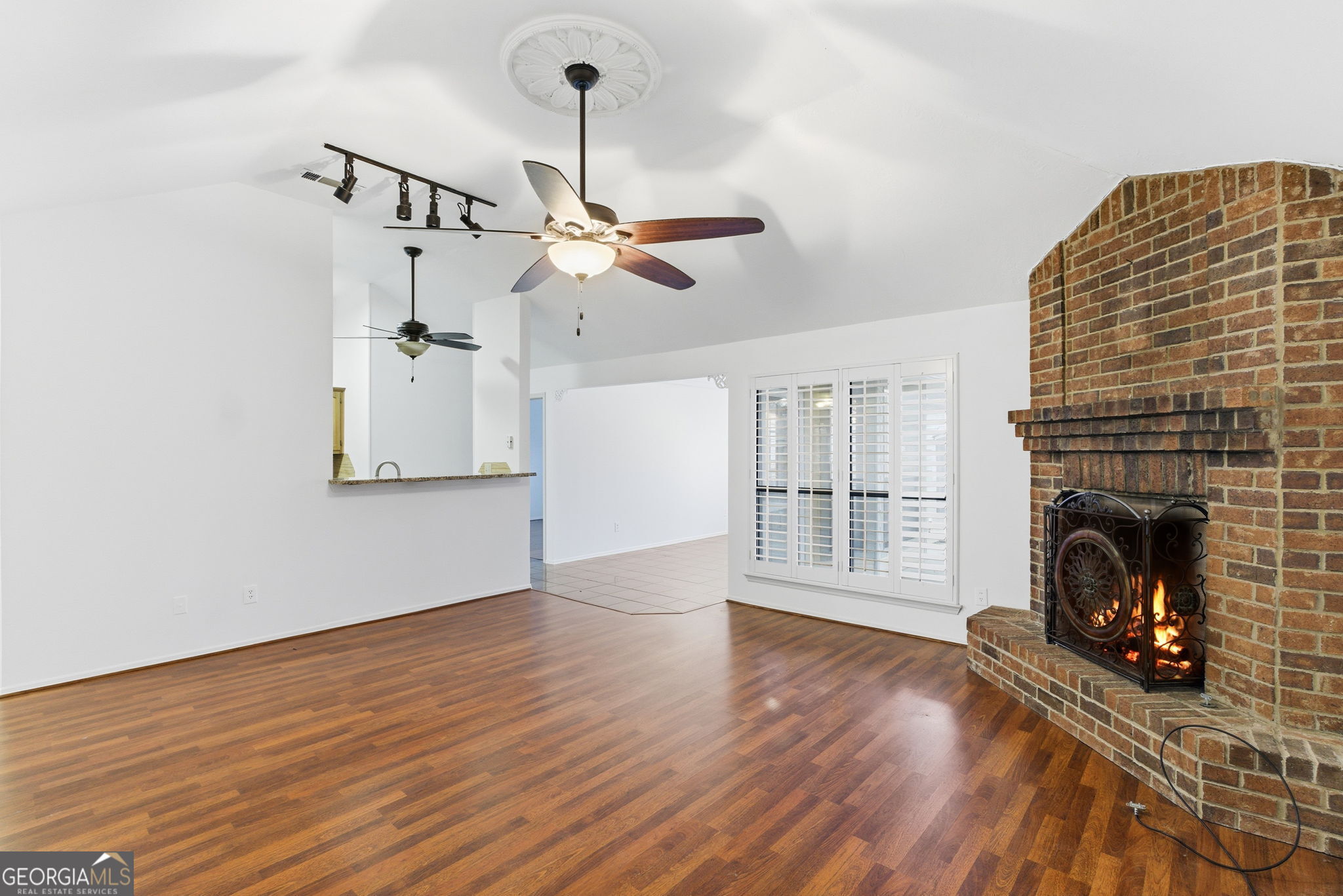 523 North Shore Road Lithonia, GA 30058 - Photo 3 of 26 a view of an empty room with wooden floor fireplace and a window