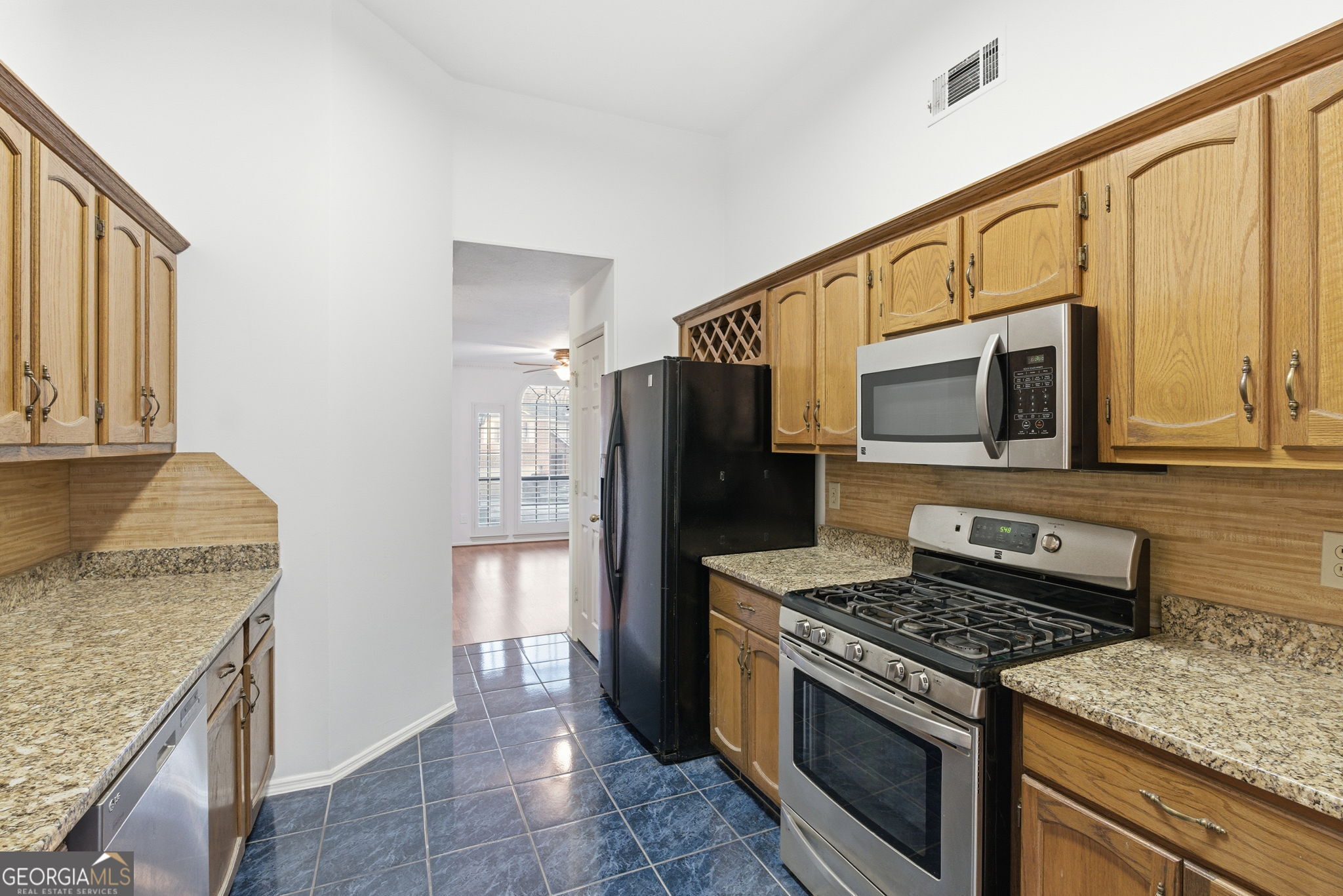 523 North Shore Road Lithonia, GA 30058 - Photo 7 of 26 a kitchen with a stove microwave and refrigerator