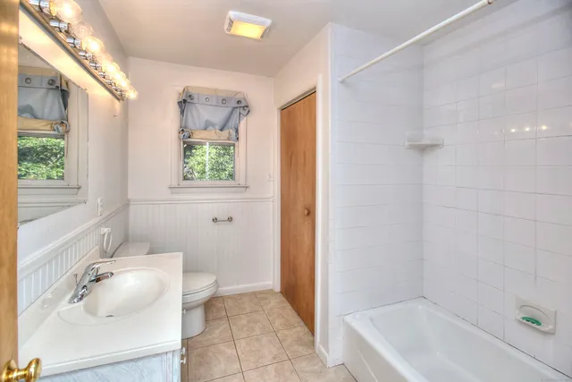 a bathroom with a granite countertop sink a toilet and shower