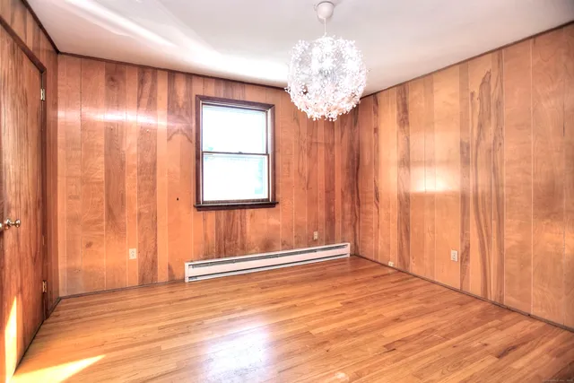 a view of a livingroom with a chandelier curtains and wooden floor