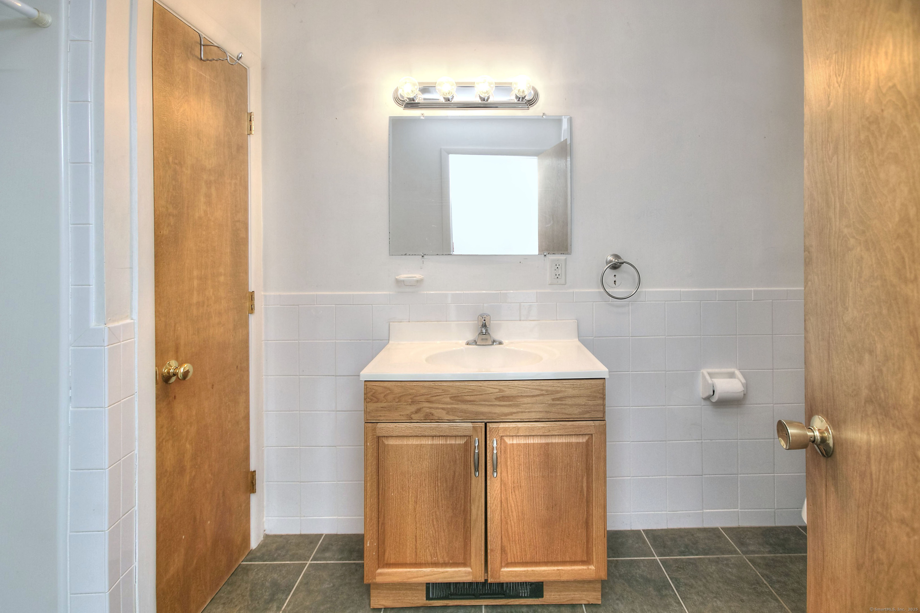 489 Main Street Westport, CT 06880 - Photo 18 of 40 a bathroom with a granite countertop sink a mirror and a shower