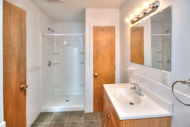 a bathroom with a sink shower and a mirror