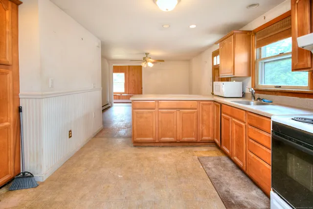 a large white kitchen with stainless steel appliances granite countertop a refrigerator and a sink