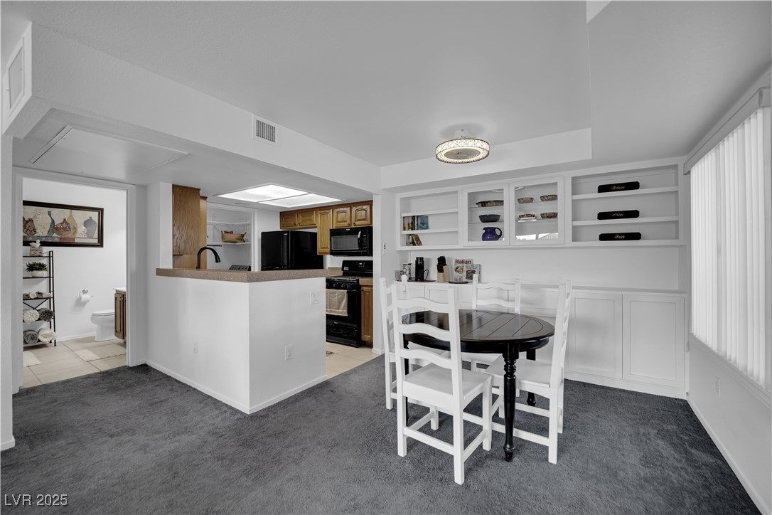 1909 Mountain Hills Court, Unit 205 Las Vegas, NV 89128 - Photo 11 of 34 Dining room featuring light carpet and built in shelves